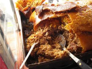 The flavored rice and meat are cooked inside the skin of the pig which is served on top of the rice for a crispy treat